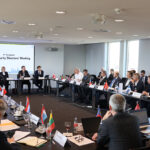 An einem großen Konferenztisch sitzen 26 europäische Cyber-Sicherheitsdirektoren beim Cyber Security Directors‘ Meeting.