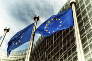 EU-Flaggen wehen vor einem mpodernen Gebäude.