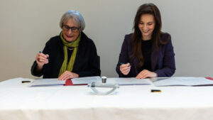 Zwei Frauen unterschreiben Verträge.