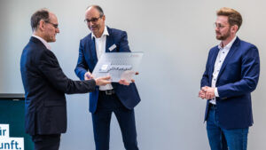 Dr. Alfred Kranstedt, Direktor des ITZBund (links), nimmt den symbolischen Schlüssel von Volker Schneider (Mitte), Leiter der Hauptstelle Erfurt des BImA-Geschäftsbereichs Facility Management entgegen. Rechts ist Aaron Weber vom Bauunternehmen ALHO Systembau GmbH zu sehen.
