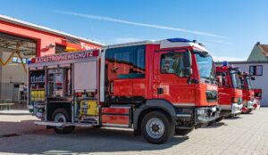 Das Bld zeigt Einsatzfahrzeuge der Feuerwehr im Hof einer Feuerwache.