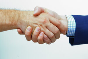 Nahaufnahme zweier männlicher Hände beim Handshake.