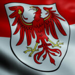 Wehende Brandenburg-Flagge mit dem Landeswappen, das einen Adler zeigt.