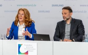 Eine Frau und ein Mann auf einem Podium, die Frau spricht gerade.