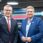 Bundesdigitalminister Dr. Karsten Wildberger und BSI-Präsidentin Claudia Plattner stehen vor einer Leinwand im Lagezentrum des BSI.