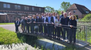 Gruppenfoto der Mitglieder des IT-Planungsrats auf einer kleinen Brücke stehend.