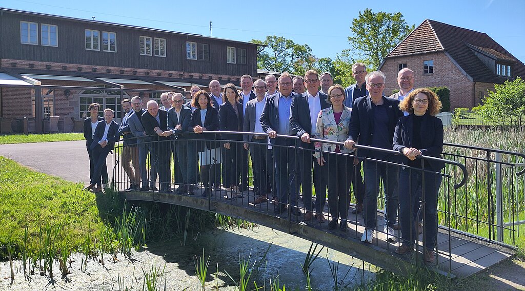 Gruppenfoto der Mitglieder des IT-Planungsrats auf einer kleinen Brücke stehend.