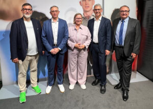 Personengruppe in Smart Casual-Kleidung hat sich zum Fototermin nebeneinander gestellt.