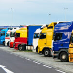 Eine Reihe von Lkws, die an einer Autobahnraststätte parken