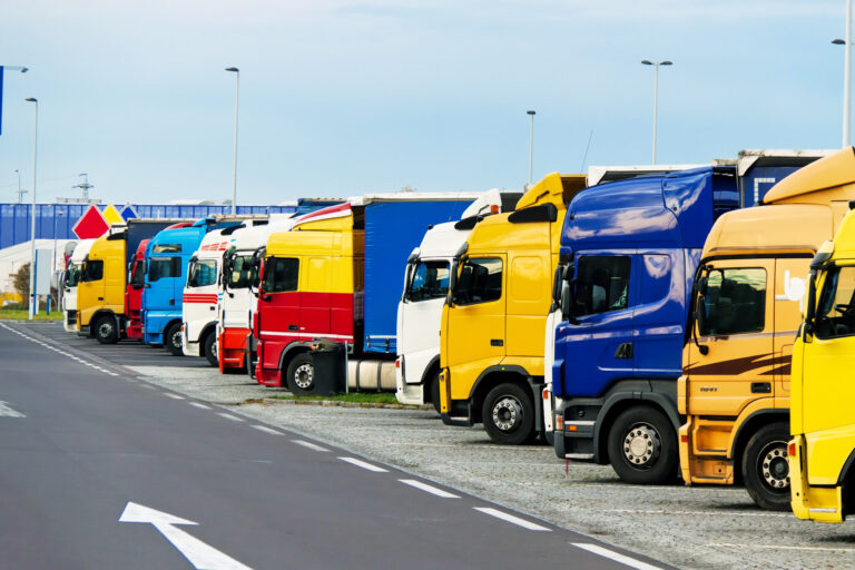 Eine Reihe von Lkws, die an einer Autobahnraststätte parken
