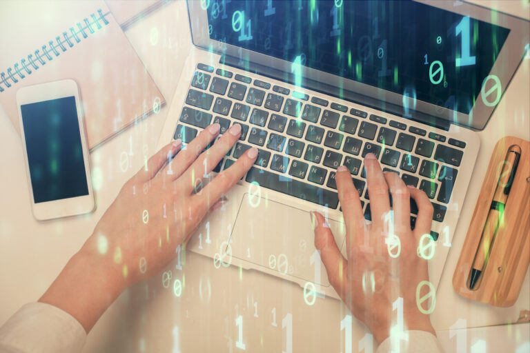 Frauenhände an einem Laptop mit einem Overlay aus Binärcode.