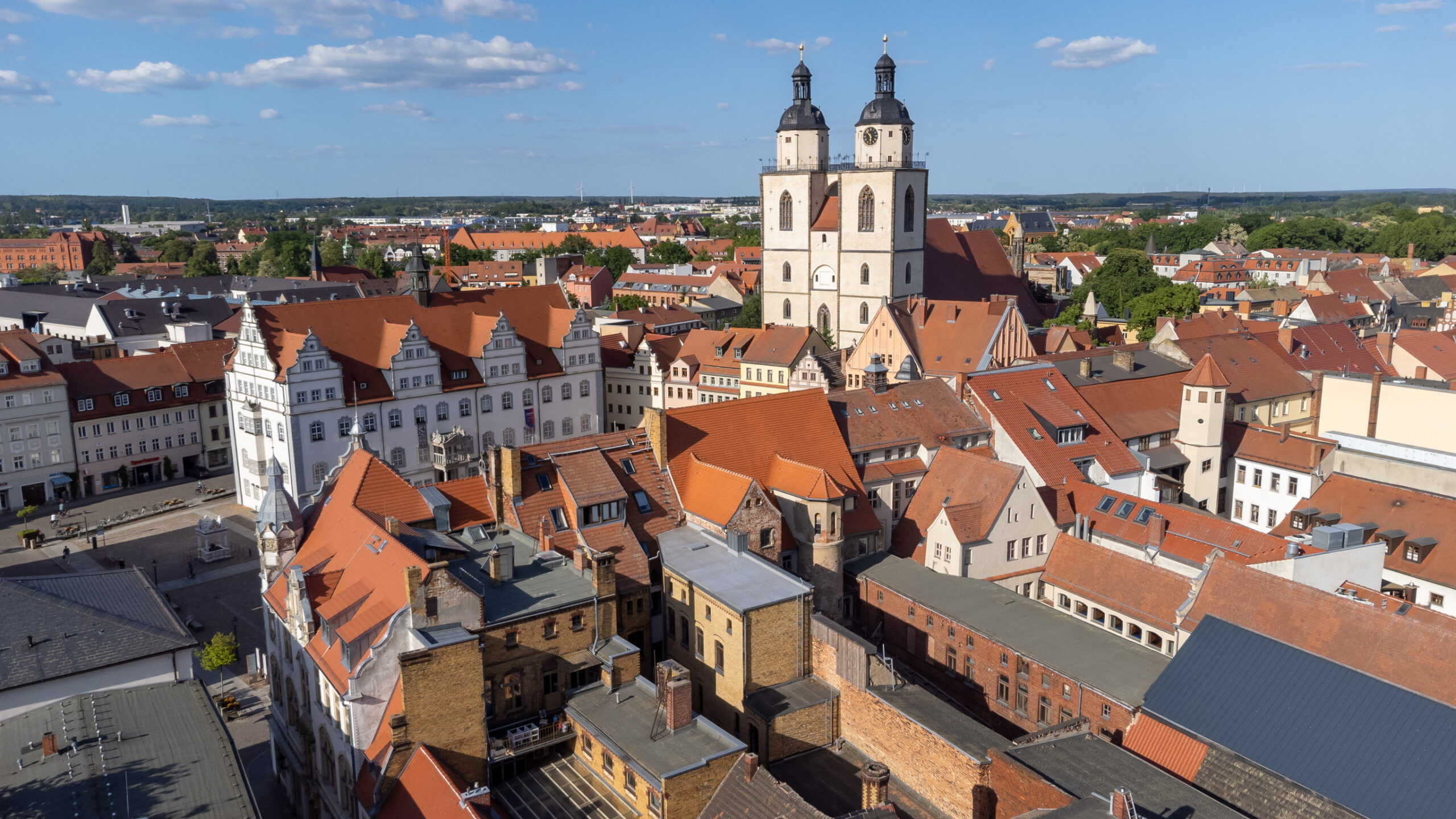 Luftaufnahme der Altstadt von Witenberg, im Bildzentrum ein heller Doppelkirchturm.