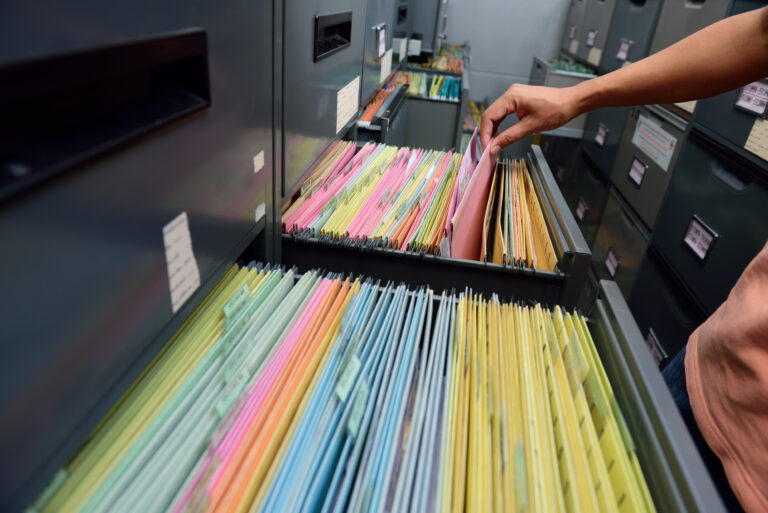 Graue Hängeregisterschränke mit Papierakten.