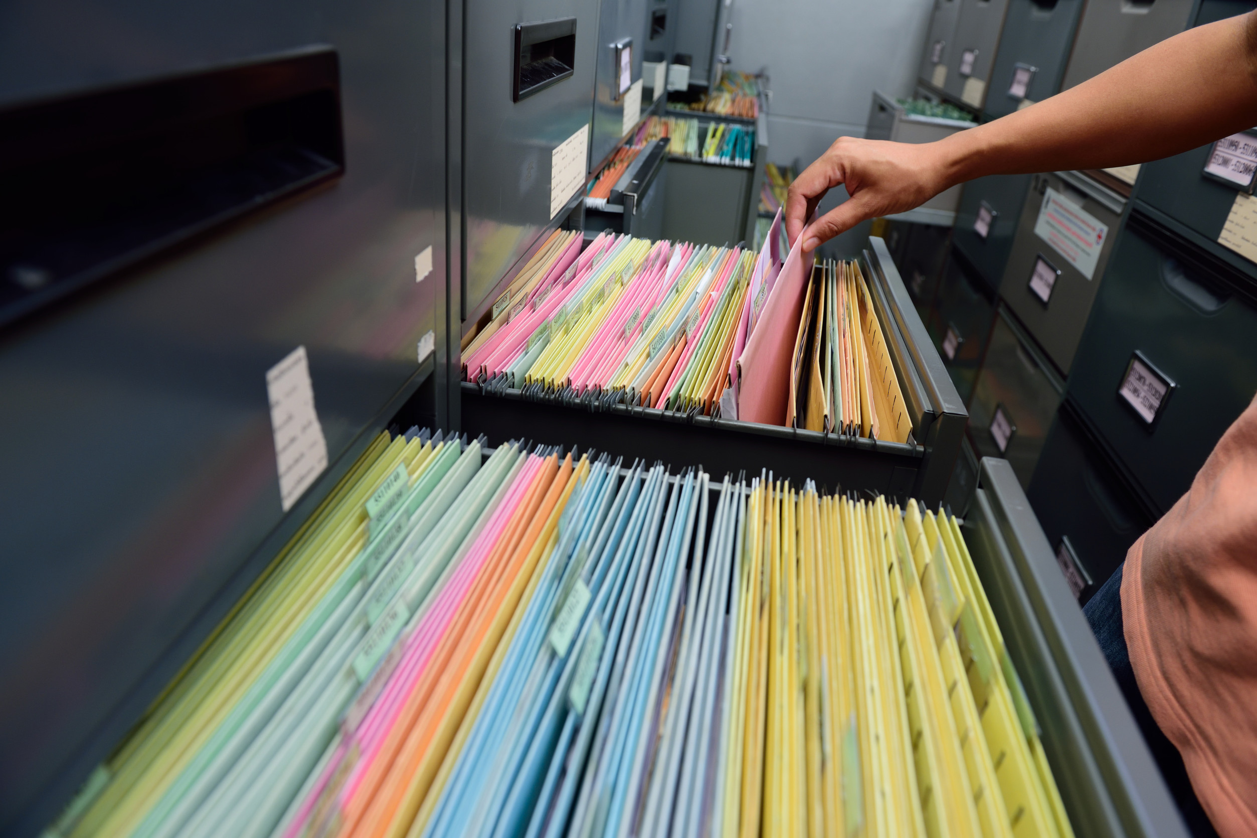 Graue Hängeregisterschränke mit Papierakten.
