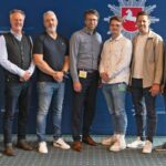 Das vorwiegend männliche Projektteam hat sich vor einer blauen Wand mit LKA-Niedersachsen-Logo zum Gruppenfoto aufgestellt.