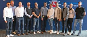 Das vorwiegend männliche Projektteam hat sich vor einer blauen Wand mit LKA-Niedersachsen-Logo zum Gruppenfoto aufgestellt.
