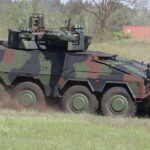 Panzepr mit Tarnfleck-Muster fährt über ein Feld.