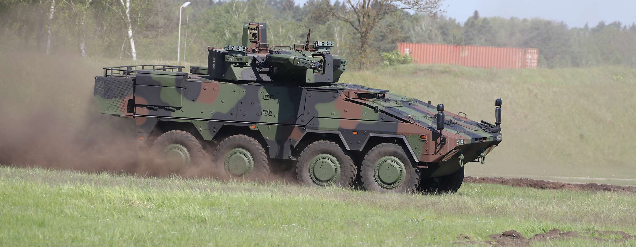 Panzepr mit Tarnfleck-Muster fährt über ein Feld.