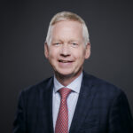 Porträt des NKR-Vorsitzenden Lutz Goebel vor dunklem Hintergrund.