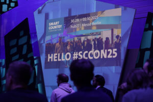 Auf einer Leinwand ist der Schriftzug Hallo SCCON 2025 zu sehen