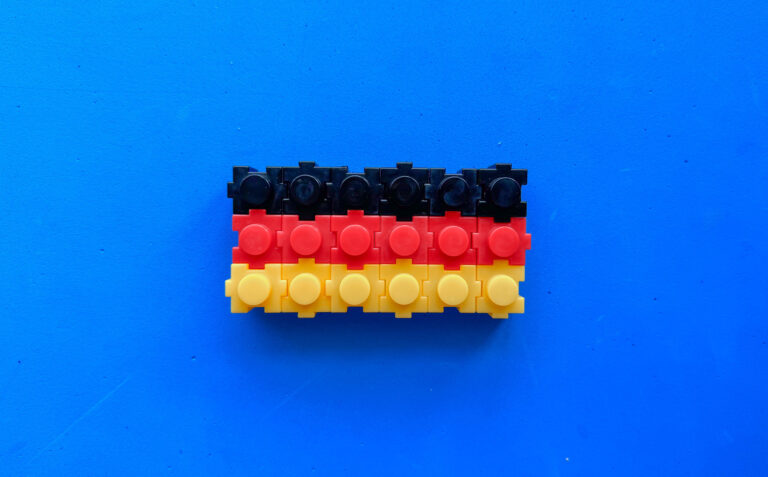 Plastikbausteine mit Noppen in den Deutschland-Farben, vor blauem Hintergrund