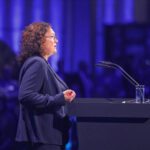 Andrea Nahles, Vorstandsvorsitzende der Bundesagentur für Arbeit, spricht auf einer Messebühne.