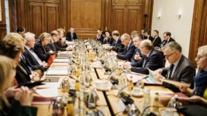 Blick über an einen langen Tisch, an dem Regierungsmitglieder sitzen.