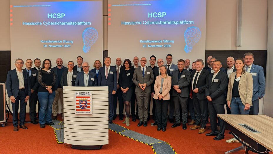 Foto einer größeren Personengruppe, die vor einer Projektion mit der Aufschrift "HCSP" posiert.