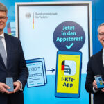 Bundesverkehrsminister Patrick Schnieder (li.) und Bundesdigitalminister Karsten Wildberger vor einer Werbewand für die neue App.