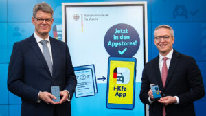 Bundesverkehrsminister Patrick Schnieder (li.) und Bundesdigitalminister Karsten Wildberger vor einer Werbewand für die neue App.