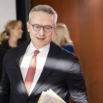 Bundesdigitalminister Karsten Wildberger mit Papiern unter dem Arm in einem dynamischen Bildsetting