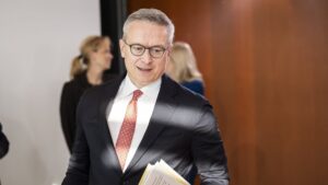 Bundesdigitalminister Karsten Wildberger mit Papiern unter dem Arm in einem dynamischen Bildsetting