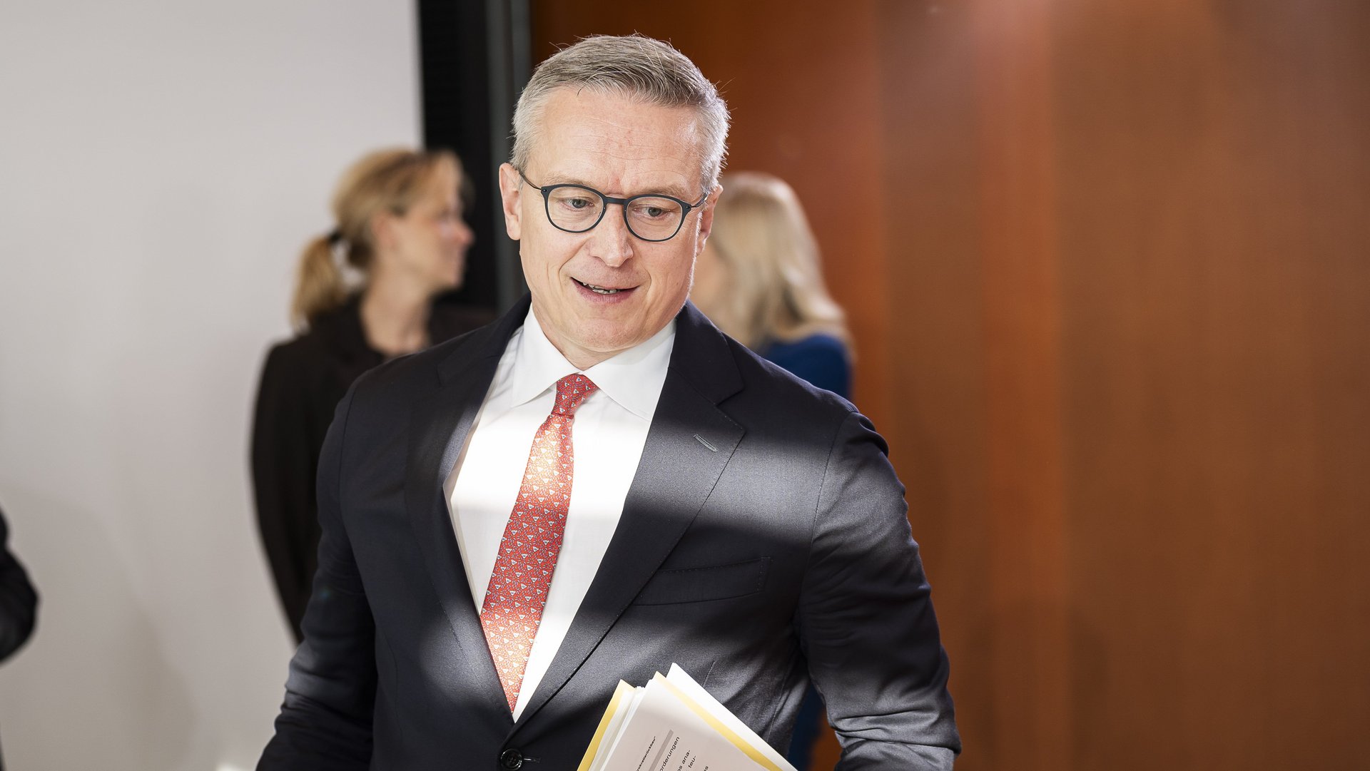 Bundesdigitalminister Karsten Wildberger mit Papiern unter dem Arm in einem dynamischen Bildsetting