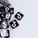 Rendering eines Stapels von TikTok-Logos auf hellgrauem Hintergrund.