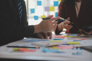 Mehrere Personen tüfteln per Brainstorming und Notizen an einer Strategie.