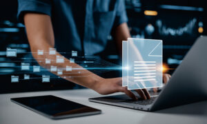 Eine Person arbeitet an einem Laptop mit digitalen Dokumenten und Ordnern.