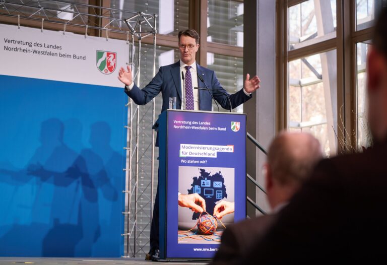 Hendrik Wüst in Segnungspose am Rednerpult.