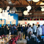 menschenmenge - die meisten personen Männer in hellblauen Oberhemden - in einem modern eingerichteten Konferenzraum.