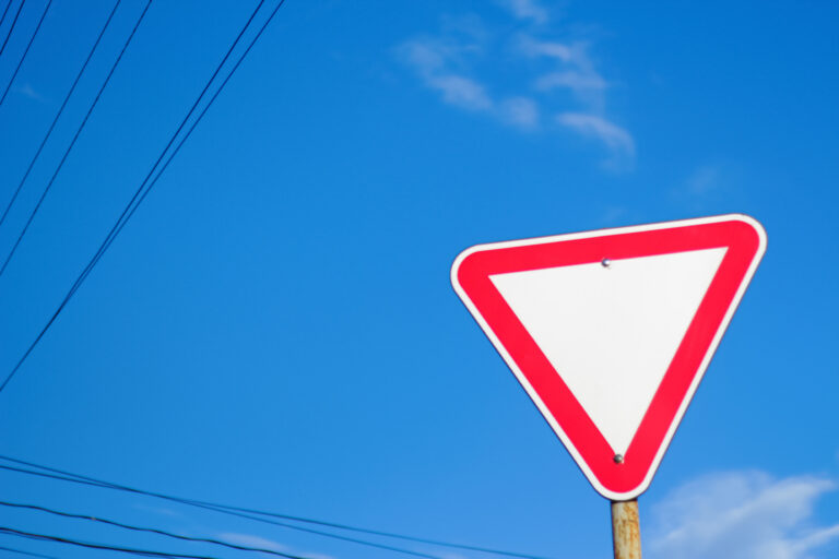 Vorfahrt-Beachten-Schild aus leichter Unzersicht gegen blauen Himmel