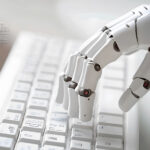 Nahaufnahme einer Hand eines futuristischen Roboters, der auf einer Tastatur tippt.