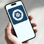 Hand hält Smartphone, darauf das Logo der BeihilfeNRW-App