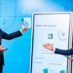 Bundesverkehrsminister Patrick Schnieder (links) präsentiert den geteilten Fahrzeugschein