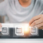 Eine jüngere Person sitzt über einem Tablet, über dem Dokumentensymbole schweben.