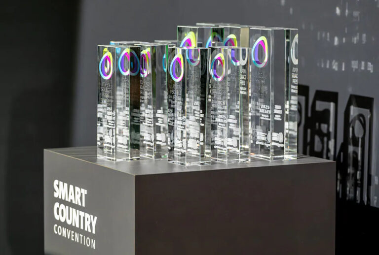 Eine Reihe von gläsernen Trophäen auf einer frauen Säule, darauf Schriftzug "Smart Country Convention"
