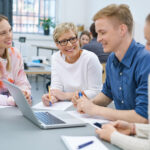 Motiviertes junges Arbveitsteam sitzt an einem Tisch