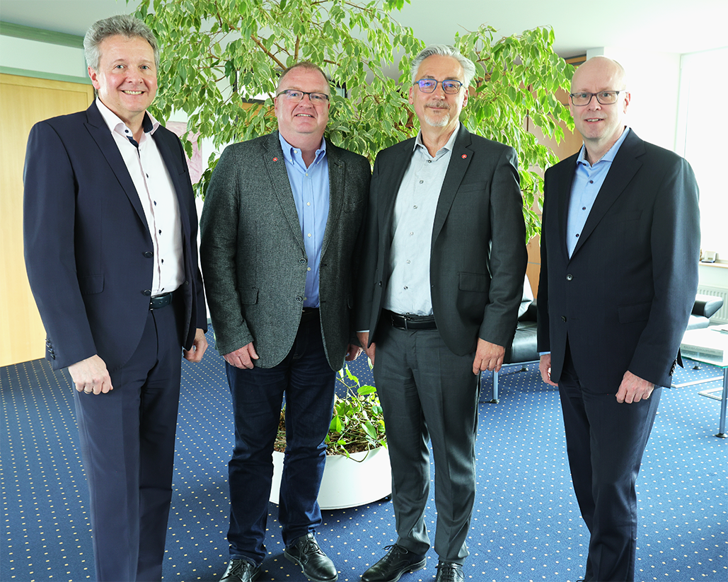 Vier_Männer_vor_einer Pflanze_partnerschaft_iBYKUS-Inwerken
