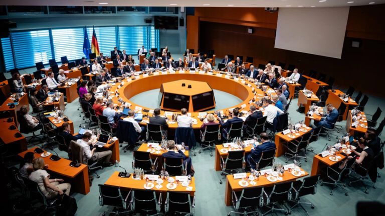 Tagungssaal mit runder Tischanordnung, gut besetzt
