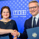 Handshake-Pose von Pakoste und Wildberger vor blauem Hintergrund