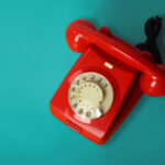 Rotes Retro-Telefon auf blauem Untergrund