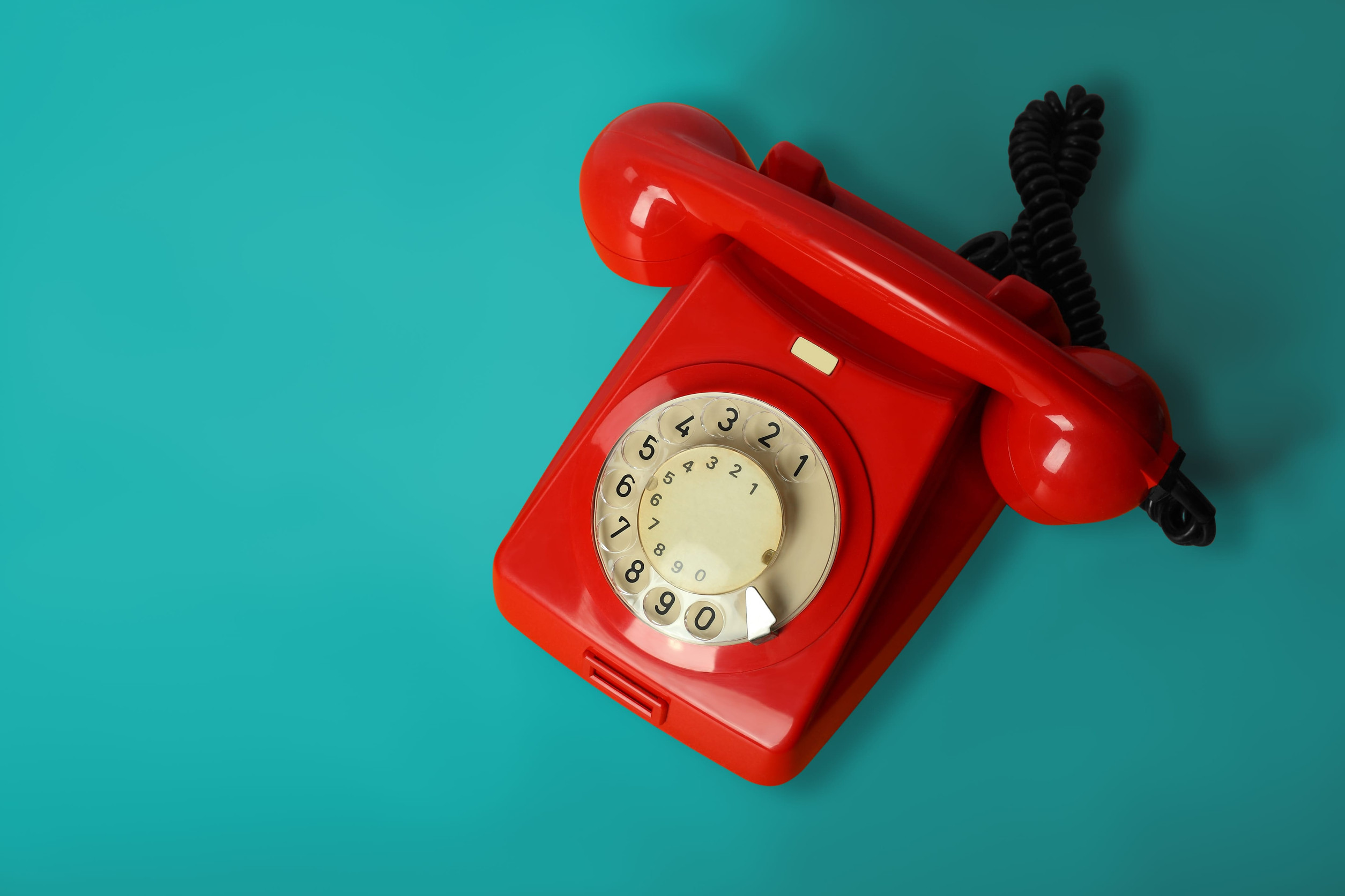 Rotes Retro-Telefon auf blauem Untergrund